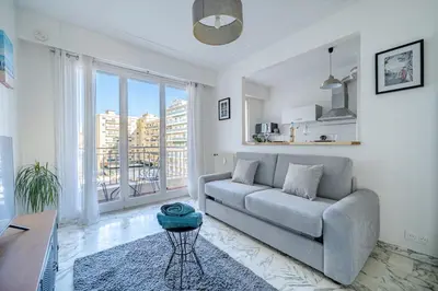 a living room with a couch and a large window at Port de Nice - Studio with balcony in Nice
