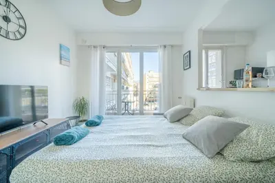 a large bed in a room with a large window at Port de Nice - Studio with balcony in Nice