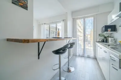 a kitchen with a bar with a wooden counter top at Port de Nice - Studio with balcony in Nice