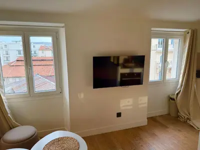 a living room with a flat screen tv on a wall at Cozy & Lumineux Studio proche mer in Nice