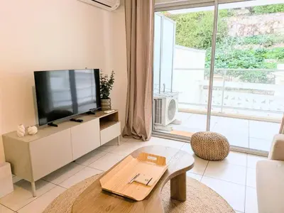 a living room with a tv and a large window at Résidence So Amata , à deux pas du Port de Nice in Nice