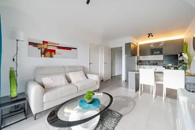a living room with a couch and a table at Superbe 2 pièces - Piscine et garage in Nice