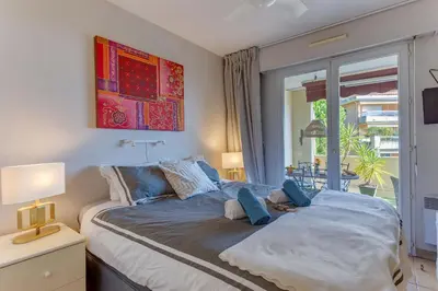 a woman laying on a bed in a bedroom at IMPERIA AP4490 by RIVIERA HOLIDAY HOMES in Nice