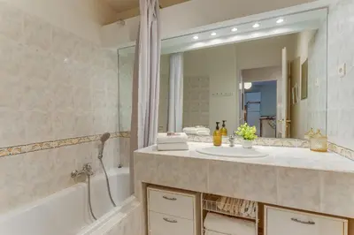 a bathroom with a sink and a tub and a mirror at IMPERIA AP4490 by RIVIERA HOLIDAY HOMES in Nice