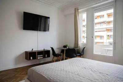 a bedroom with a bed and a table and chairs at Appartement-Suite neuf - 2 chambres - 1 min mer in Nice