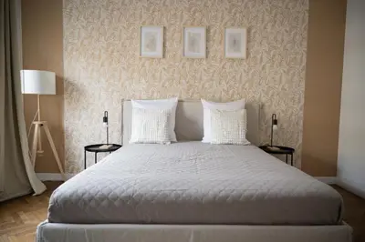 a bedroom with a bed with two lamps and two pictures on the wall at Appartement-Suite neuf - 2 chambres - 1 min mer in Nice
