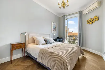 a white bedroom with a bed and a window at Nice Renting - AMOUR - Haussmann Luxury Sea Balcony Free Parking in Nice