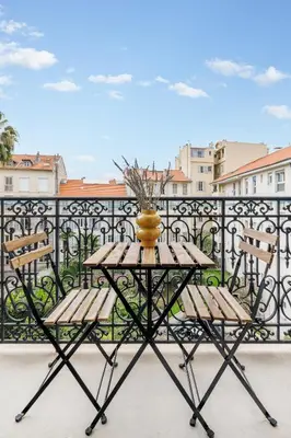 a table with two chairs and a vase on a balcony at Nice Renting - AMOUR - Haussmann Luxury Sea Balcony Free Parking in Nice