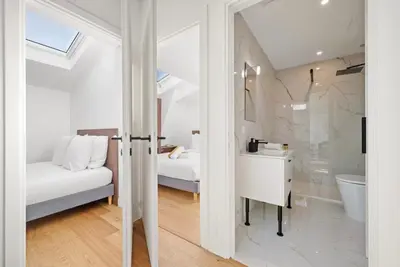 a white room with a bed and a bathroom at Emplacement exceptionnel Deux Chambres AC WIFI in Nice