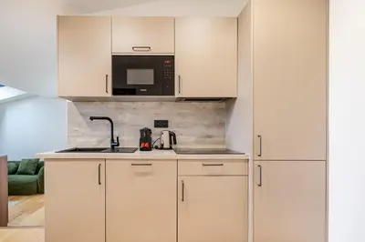 a kitchen with white cabinets and a sink and a microwave at Emplacement exceptionnel Deux Chambres AC WIFI in Nice