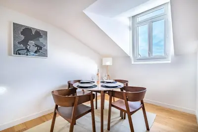 a dining room with a table and chairs and a window at Emplacement exceptionnel Deux Chambres AC WIFI in Nice