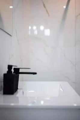 a white bathroom with a sink and a faucet at Emplacement exceptionnel Deux Chambres AC WIFI in Nice