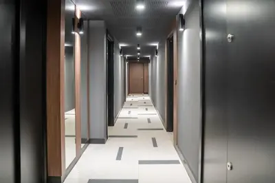 a hallway with black and white tile floors and a door at Superbe T2 Neuf avec Terrasse Hyper Centre Nice in Nice