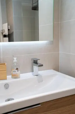 a bathroom sink with a bottle of soap on it at Superbe T2 Neuf avec Terrasse Hyper Centre Nice in Nice