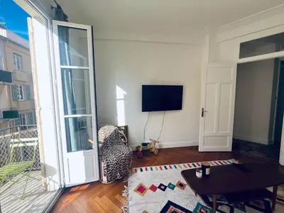 a living room with a chair and a television at 2P de charme proche gare et hyper centre Nice in Nice