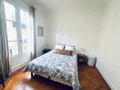 a bedroom with a bed and a large window at 2P de charme proche gare et hyper centre Nice in Nice