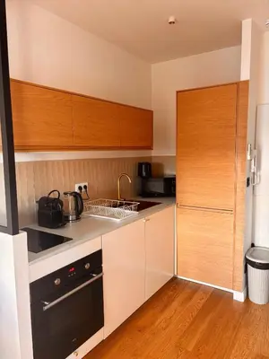 a kitchen with white cabinets and a black appliance at Atelier de Lumière Nice Gambetta in Nice