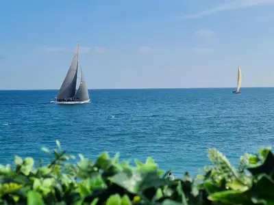 a sail boat in the ocean with two sail boats at Atelier de Lumière Nice Gambetta in Nice