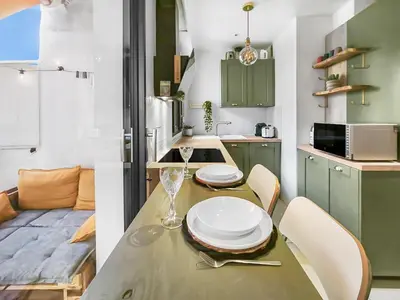 a kitchen with a table with plates and glasses on it at Central, élégant & cosy in Nice