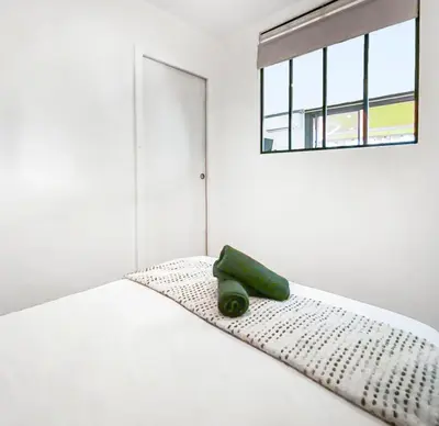 a white bed with a green object sitting on it at Central, élégant & cosy in Nice