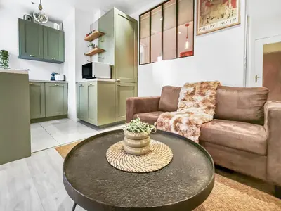 a living room with a table and a couch at Central, élégant & cosy in Nice