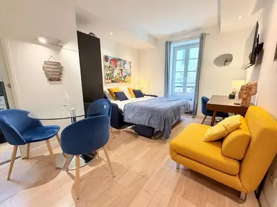 a bedroom with a bed and a couch and a table at Studio design et lumineux près du Port de Nice in Nice