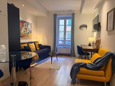 a living room with a couch and a table at Studio design et lumineux près du Port de Nice in Nice