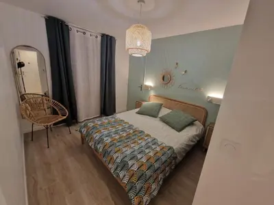 a bedroom with a bed and a chair and a mirror at Alex&Chris in Nice