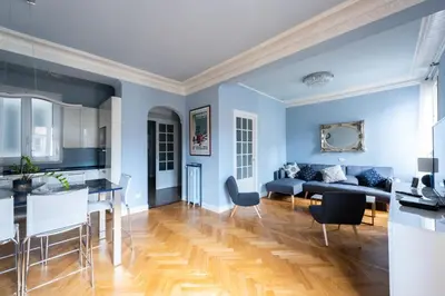 a living room with blue walls and a table and chairs at La Suite Londres in Nice