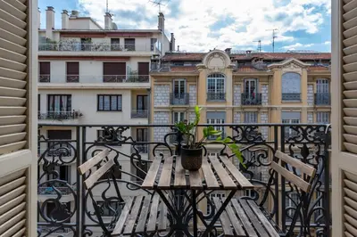a balcony with a table and benches on a balcony at La Suite Londres in Nice