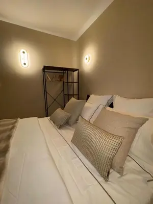 a large white bed with pillows in a bedroom at Authentic Provençal Studio in Nice