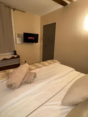 a bedroom with a bed with a tv on the wall at Authentic Provençal Studio in Nice