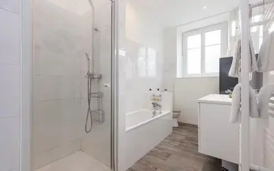a white bathroom with a shower and a tub at Appartement 2 chambres Nice Jean Medecin in Nice