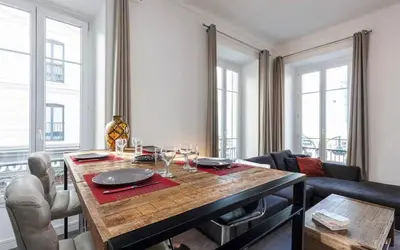 a living room with a wooden table with wine glasses at Appartement 2 chambres Nice Jean Medecin in Nice