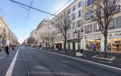 an empty street with buildings and people walking on the street at Appartement 2 chambres Nice Jean Medecin in Nice