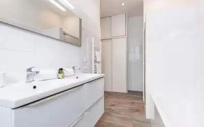 a white bathroom with a sink and a mirror at Appartement 2 chambres Nice Jean Medecin in Nice