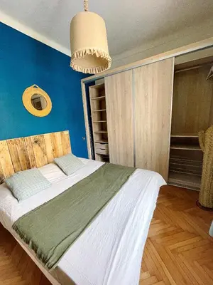 a bedroom with a large bed with a blue wall at Appartement 2 pièces bourgeois meublé, aéroport tramway in Nice