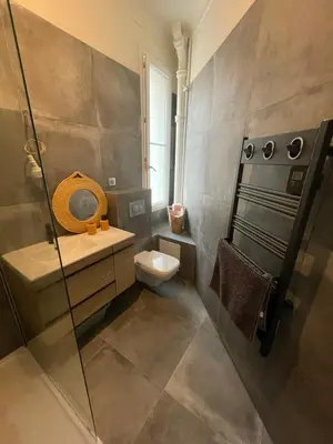a bathroom with a toilet and a glass shower at Appartement 2 pièces bourgeois meublé, aéroport tramway in Nice