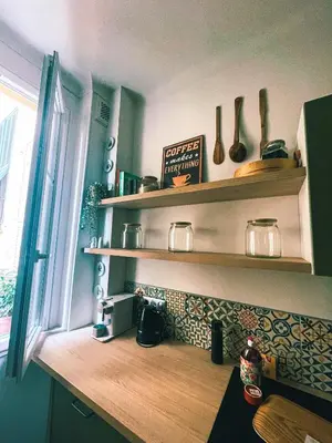 a kitchen with wooden shelves and a window at Appartement 2 pièces bourgeois meublé, aéroport tramway in Nice
