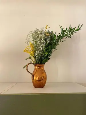 a vase filled with flowers sitting on a shelf at Appartement 2 pièces bourgeois meublé, aéroport tramway in Nice