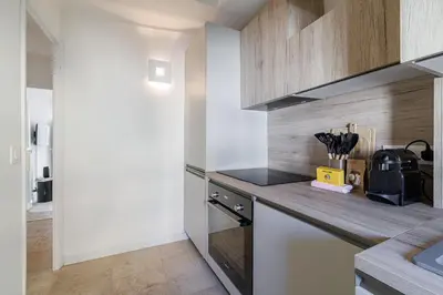 a kitchen with wooden cabinets and a counter top at Charming Ultra Central 1 Bdr in Nice