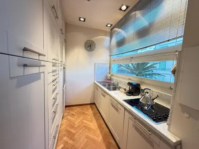 a kitchen with white cabinets and a sink and a window at Casa Giacometti Vue Mer Lumiere et Horizon in Nice