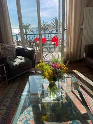 a living room with a glass table with flowers on it at Casa Giacometti Vue Mer Lumiere et Horizon in Nice