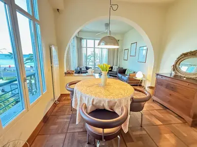 a dining room with a table with chairs and a living room at Casa Giacometti Vue Mer Lumiere et Horizon in Nice