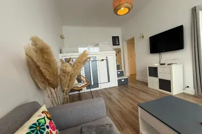 a living room with a couch and a tv at Beautiful studio apartment just a stone's throw from the beach in Nice