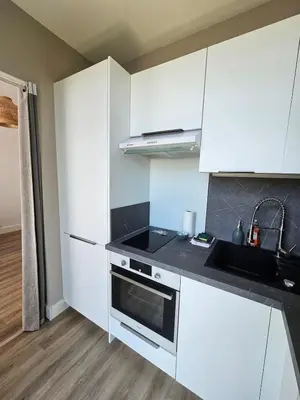 a white kitchen with a sink and a stove at Beautiful studio apartment just a stone's throw from the beach in Nice