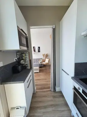 a kitchen with white cabinets and a dining room at Beautiful studio apartment just a stone's throw from the beach in Nice