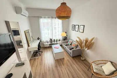 a living room with a couch and a tv at Beautiful studio apartment just a stone's throw from the beach in Nice
