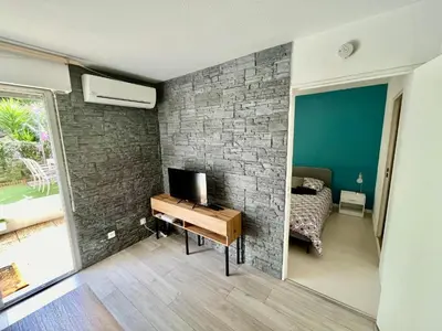 a bedroom with a brick wall and a desk with a television at Le riviera bay avec parking in Saint-Laurent-du-Var