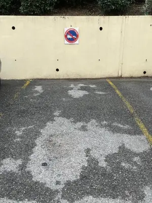a parking lot with a sign on the side of a wall at Le riviera bay avec parking in Saint-Laurent-du-Var